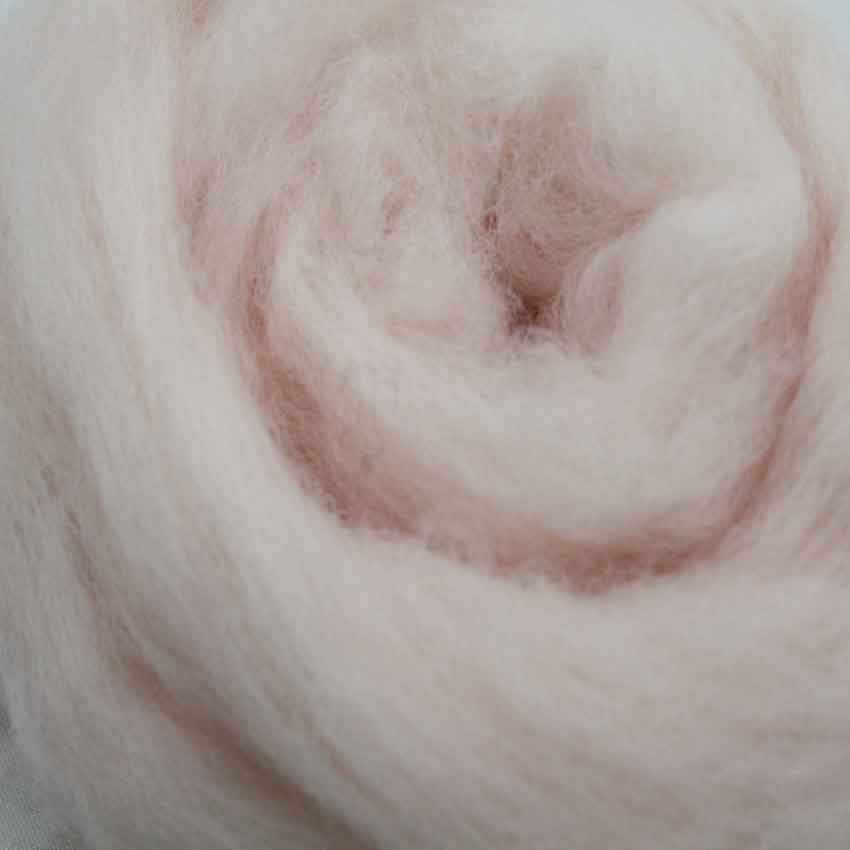 close up of corrie wool top for felting in soft peach colour