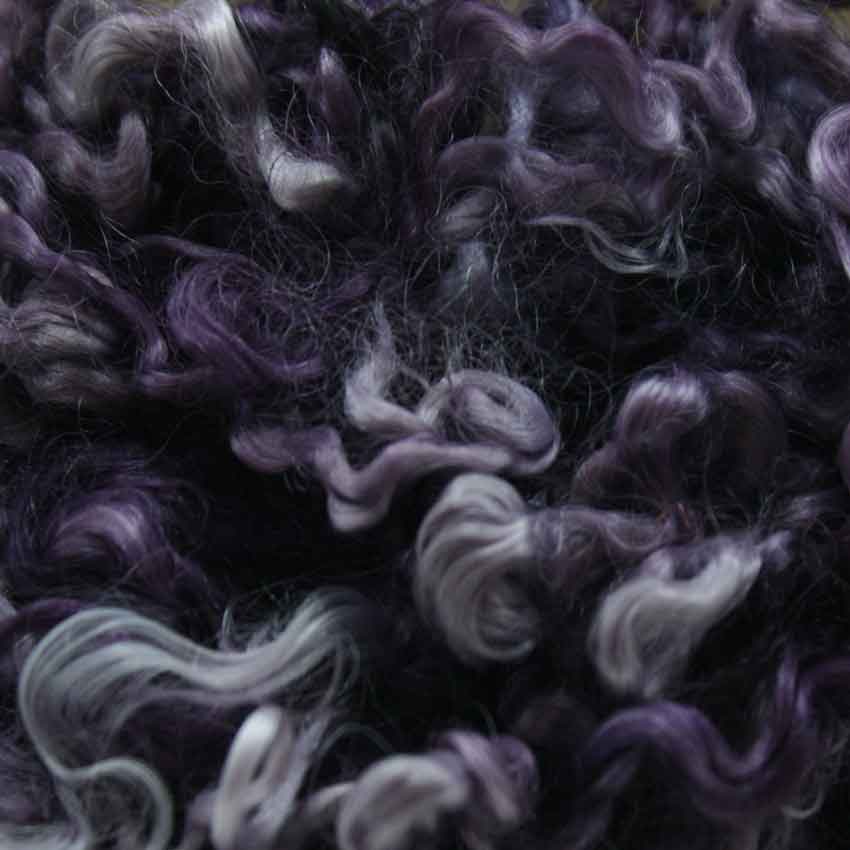 Close up of lavender mohair curls showing varying shades light to medium dusty purple