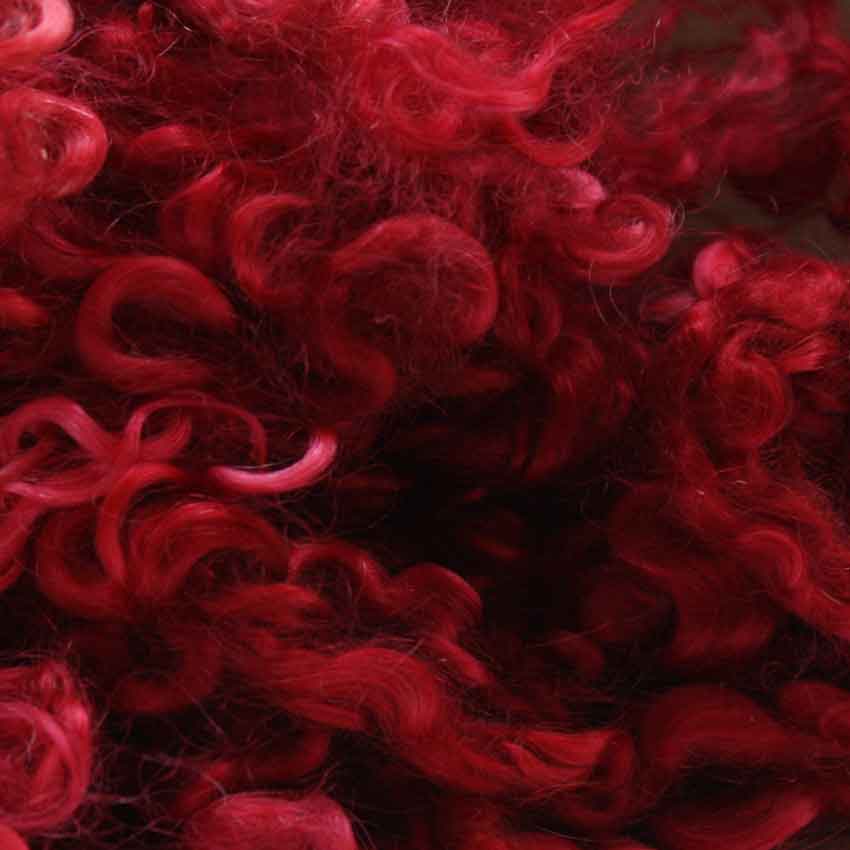 Close up of scarlet mohair curls showing deep strong crimson red
