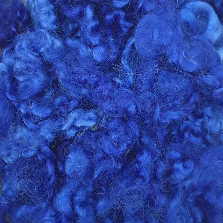 Close up of royal mohair curls showing a rich dark shade of blue colours