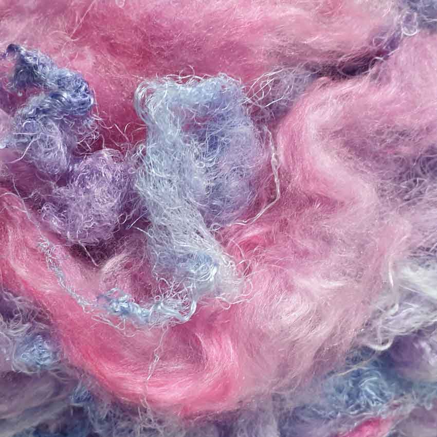 close up  of hand dyed silk filament in blues, pink, reds and purples
